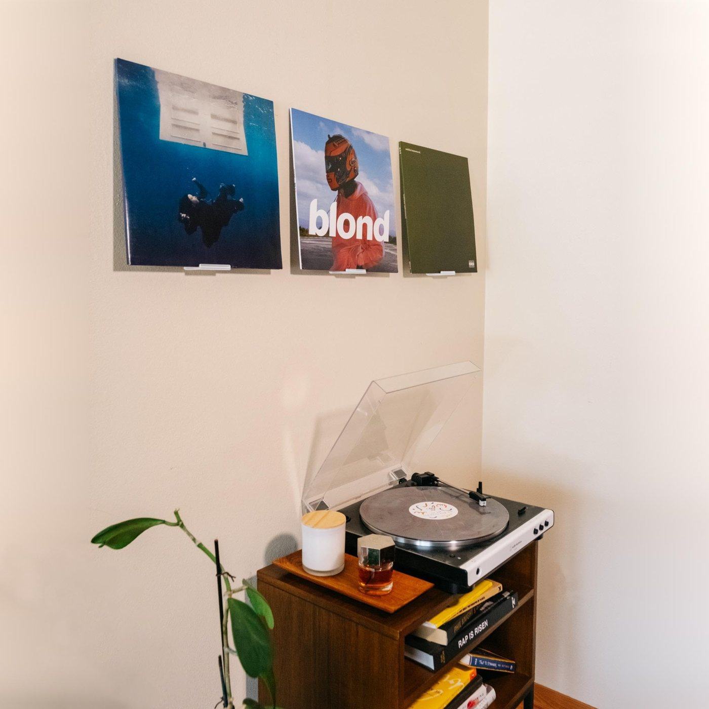 Album covers on slim wall ledges above a turntable